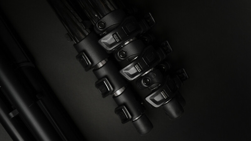 Close-up of four black combination padlocks arranged vertically against a dark background.