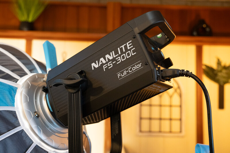 Nanlite LS-300C full-color LED light mounted on a stand with a reflector modifier attached.