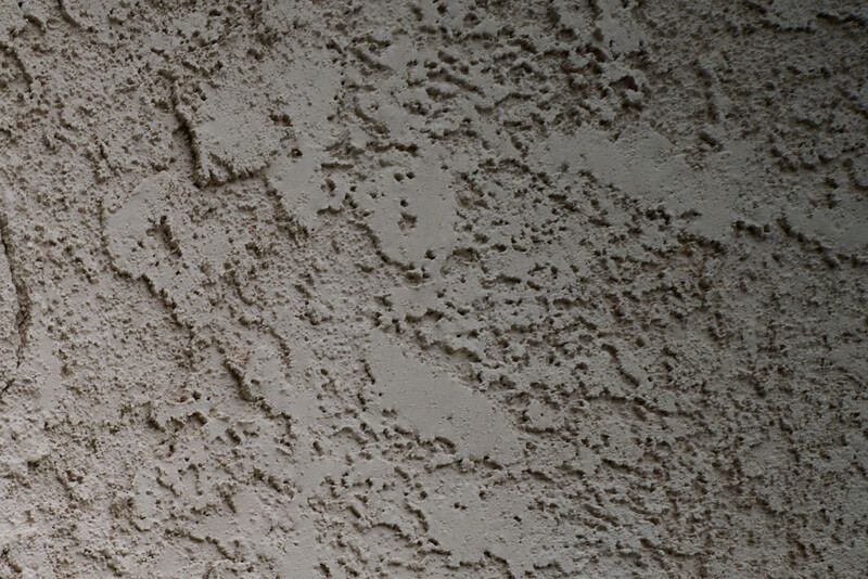 Close-up texture of rough concrete surface with varied depth and porous details.
