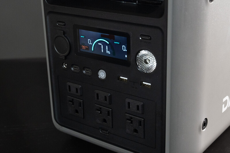 Portable power station with digital display, multiple AC outlets, and control panel with illuminated buttons.