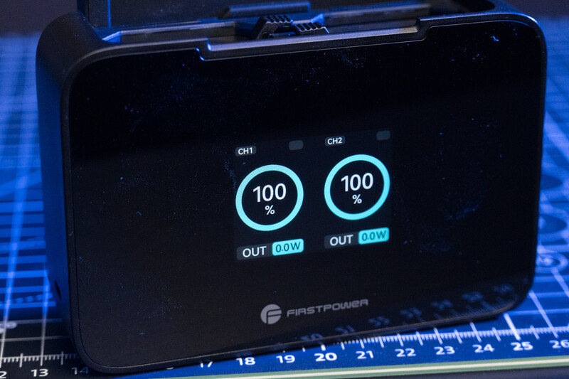Screenshot of FirstPower battery display showing two channels at 100% capacity with 0.0W output each.