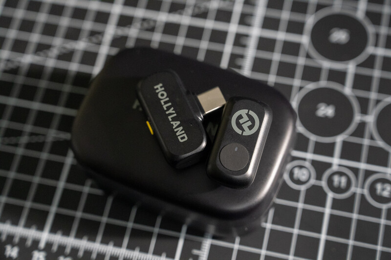 Wireless microphone transmitter and receiver set displayed on a gridded surface.