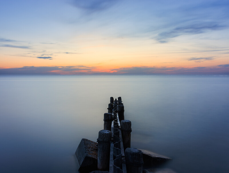 Long exposure photograph of a breakwater extending into Lake Michigan after sunset