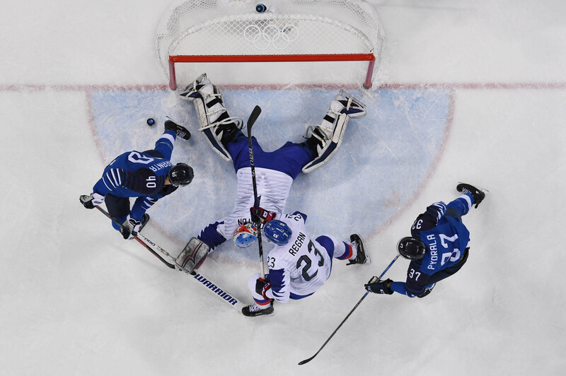 Overhead view of hockey players competing for the puck near the goal during a game.