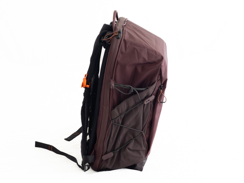 Burgundy backpack with black straps and orange accents shown in profile view against white background.