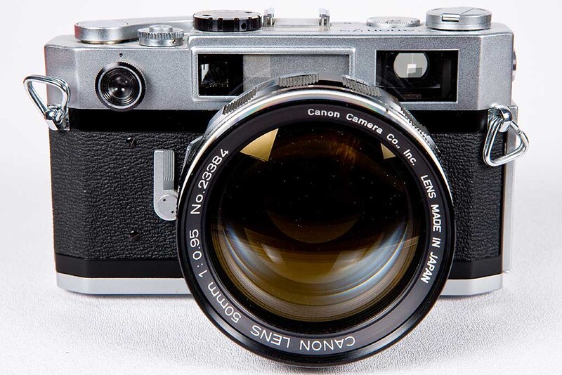 Canon rangefinder camera with chrome top plate and black leather body, fitted with a fast telephoto lens.