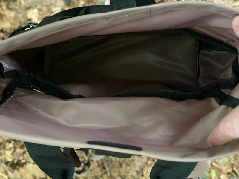 Open camera bag with gray interior compartments and black straps visible.