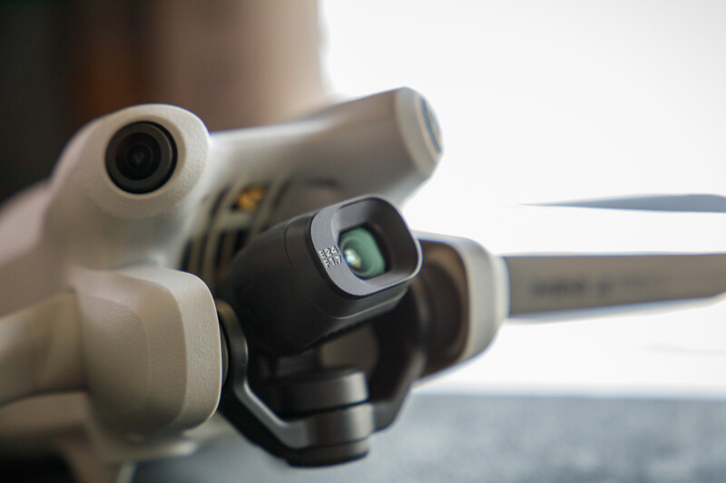 Close-up of binoculars with white eyecups and black center focusing mechanism against blurred background.