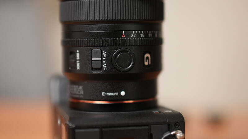 Sony E-mount lens mounted on camera body, showing aperture ring and autofocus switch.