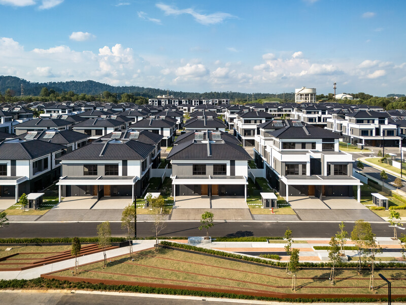 Aerial view of a modern residential development with uniform two-story townhouses arranged in rows along streets.