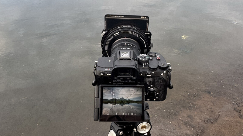 Camera rig setup photographed from above, showing external monitor displaying live view feed and cinema lens with matte box.