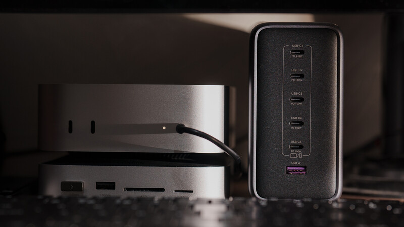 Two modern charging devices with multiple USB ports arranged on a dark surface with dramatic side lighting.