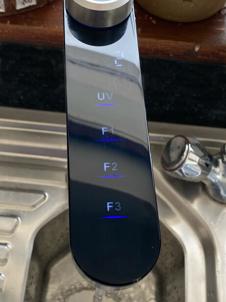 UV filter comparison chart mounted on a stand showing four filter types labeled UV, F1, F2, and F3.