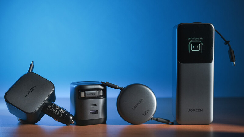 Collection of five black electronic charging devices and adapters arranged on a surface against a blue gradient background.