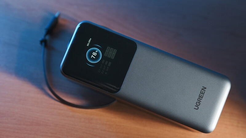 Ugreen portable power bank with digital display showing battery percentage and power icon.