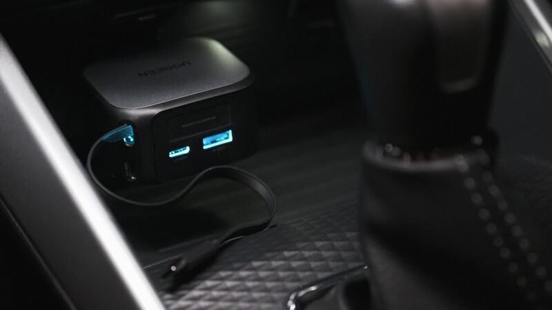Car interior with dual USB charging ports illuminated in blue, mounted on dashboard.