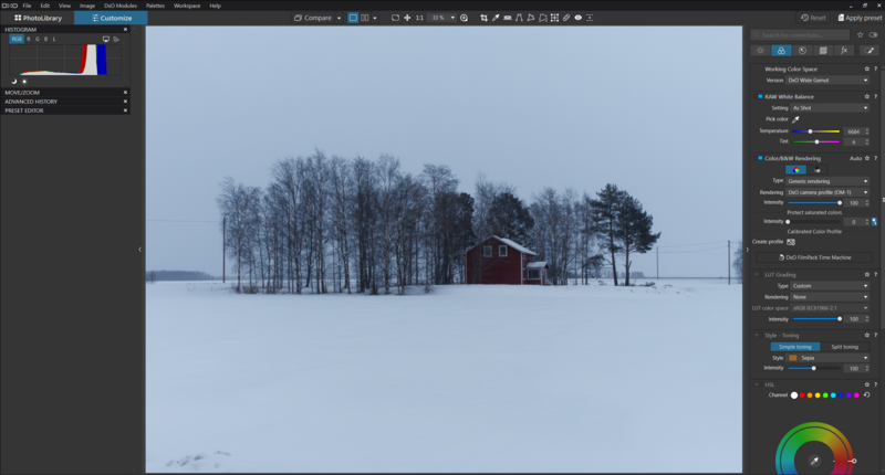 Red barn surrounded by bare trees in a snowy winter landscape under overcast sky.