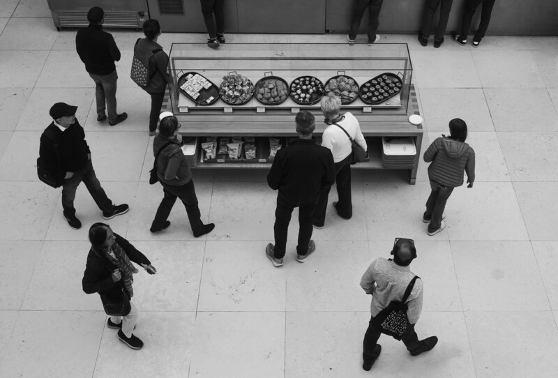Overhead view of people around a glass display counter in a retail space.