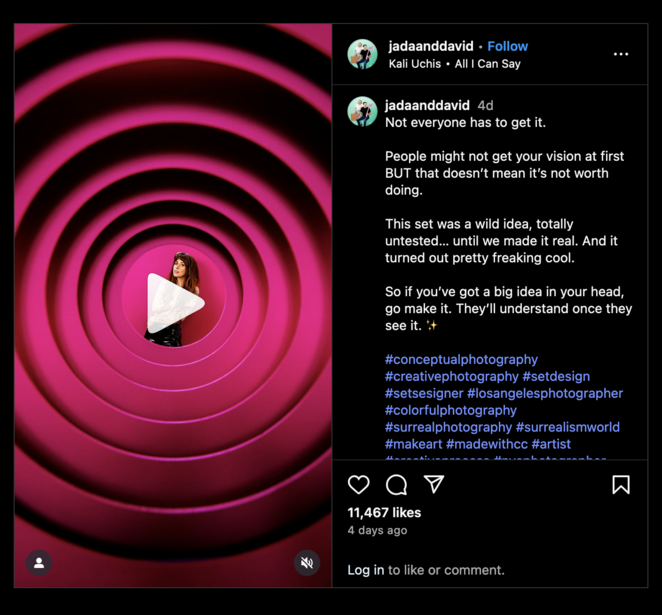 Concentric pink and magenta spiral circles with a play button overlay on dark background.
