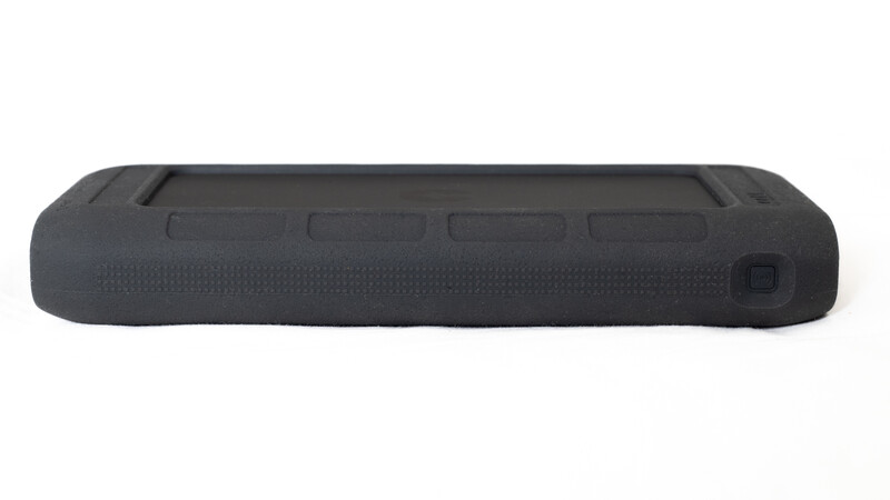 Black protective camera strap or carrying pad with textured surface and mounting hardware.