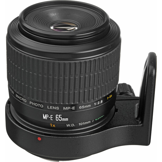 Olympus MP-E 65mm macro lens mounted on a black tripod collar foot against white background.
