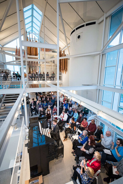 Overhead view of a crowded interior atrium with two-story heights, modern architecture, and natural skylight illumination.