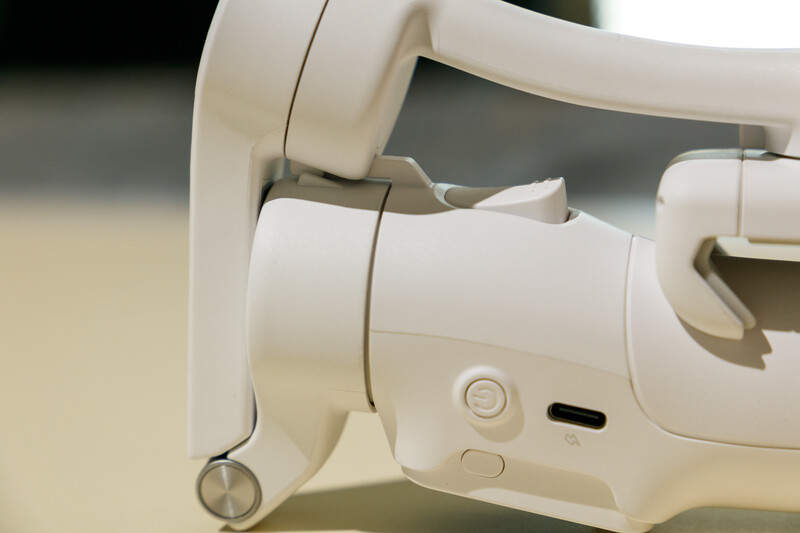 Close-up of white VR headset showing control buttons and adjustment mechanisms on the side panel.