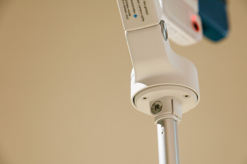 Close-up of a white studio light head mounted on a stand against a neutral beige background.