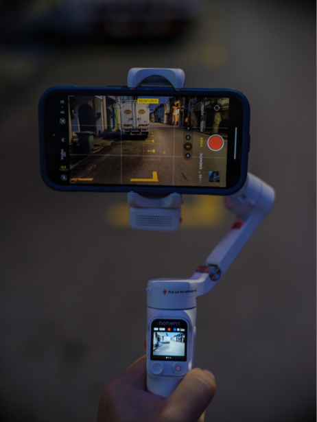 Smartphone mounted on a blue gimbal stabilizer displaying video recording interface.