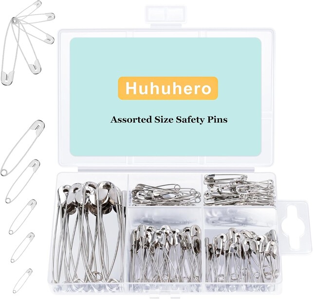 Huhuhero assorted size safety pins organized in clear plastic compartments with product packaging.