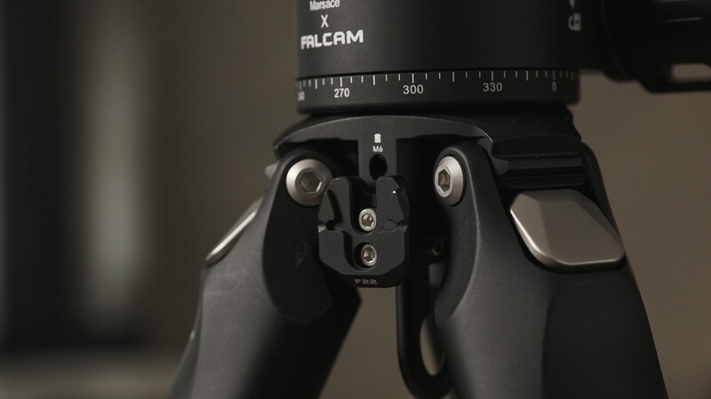 Close-up of a professional tripod head with panoramic rotation scale and adjustment knobs.