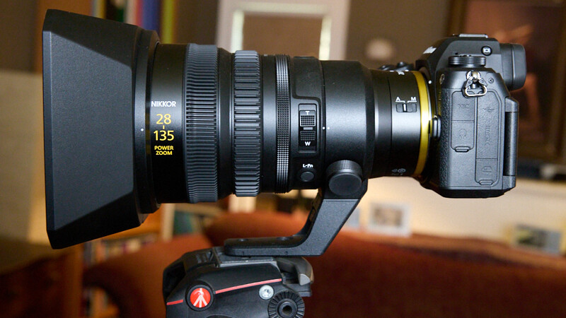 Nikon Z mirrorless camera mounted on fluid head tripod with telephoto zoom lens and matte box attachment.