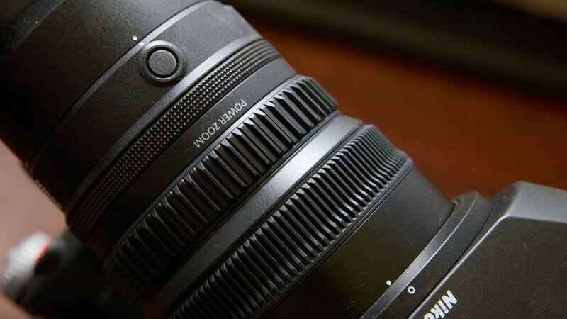 Close-up of a telephoto lens barrel showing focus ring and distance scale markings.