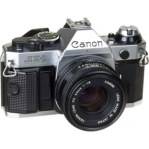 Canon AE-1 35mm SLR camera with standard lens, shown from front three-quarter view against white background.