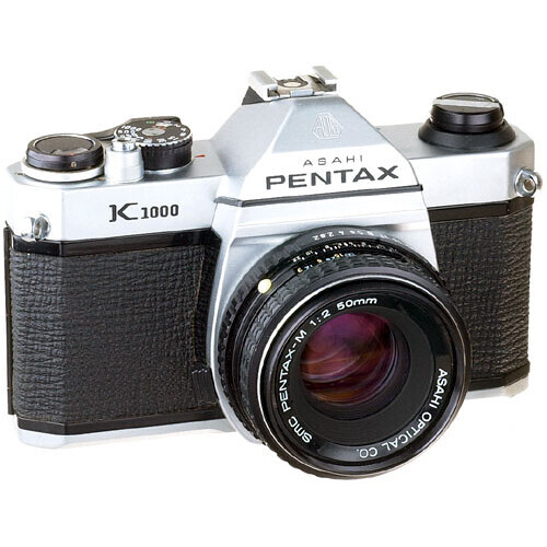 Pentax K1000 film camera with white and black body and standard prime lens.