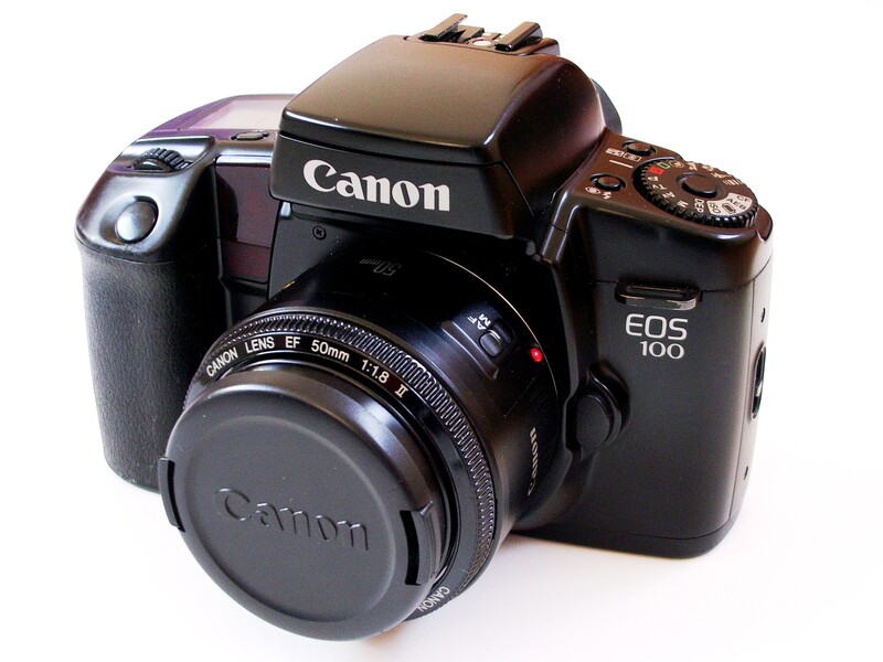 Collection of three Canon film cameras arranged on white background.