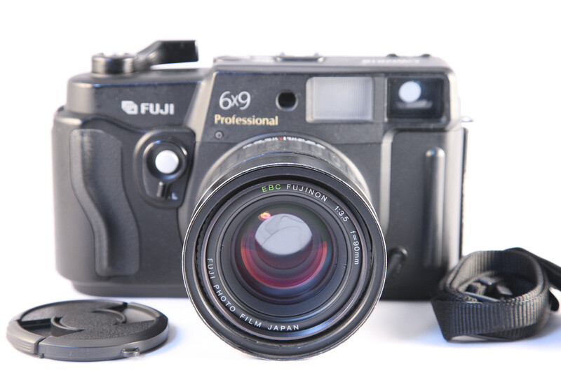 Fuji 6x9 Professional rangefinder camera with lens cap and strap displayed on white background.