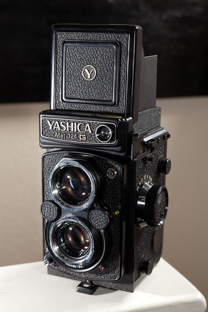 Yashica twin-lens reflex camera with dual viewing lenses mounted on top, shown against a neutral background.