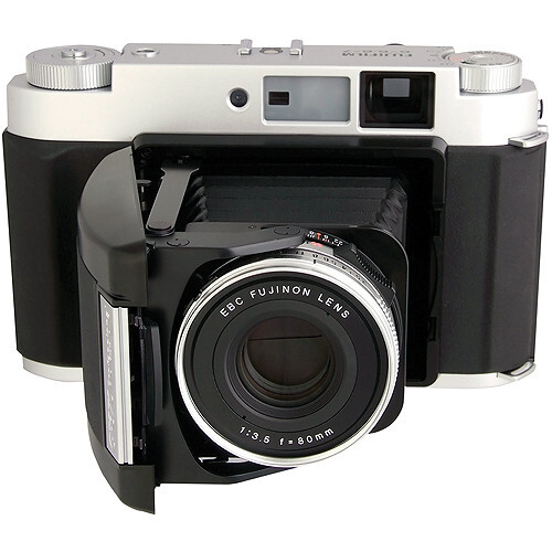 Folding camera with chrome top plate, black body, and front-mounted rangefinder lens.
