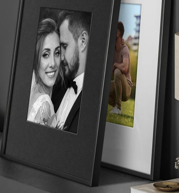 Open matted photo frames displaying black and white portrait and color landscape photographs.