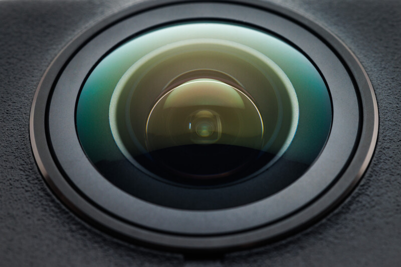 Close-up macro photograph of a wide-angle lens front element showing concentric glass rings and optical coatings.