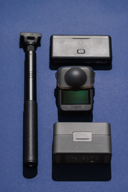 Flash unit and accessories disassembled and arranged on blue background.