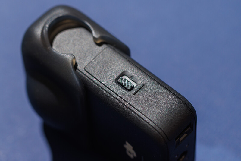 Close-up of a black camera body showing the shutter button and top plate detail against a blue background.