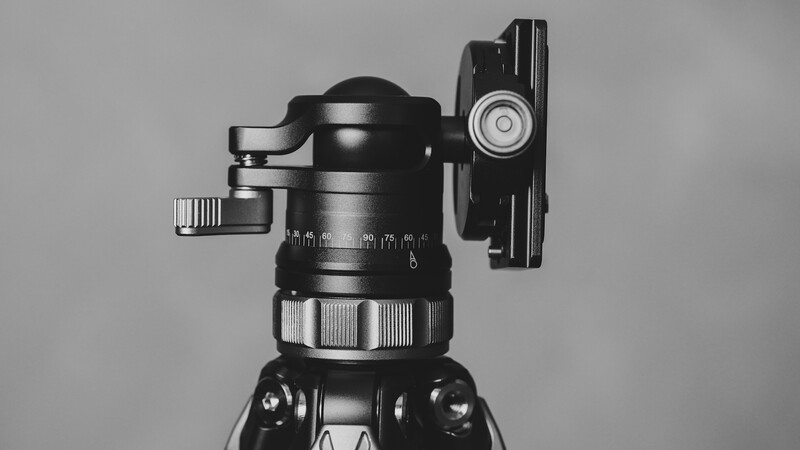 Ball head tripod mount with quick-release plate and pan-tilt controls, photographed against neutral background.