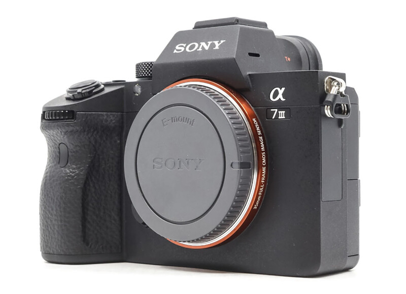 Sony α7 III mirrorless camera body with orange accent ring around lens mount.