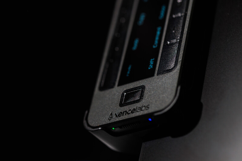 Close-up of a Xencelabs pen display tablet with blue illuminated buttons and port connectors against a dark background.