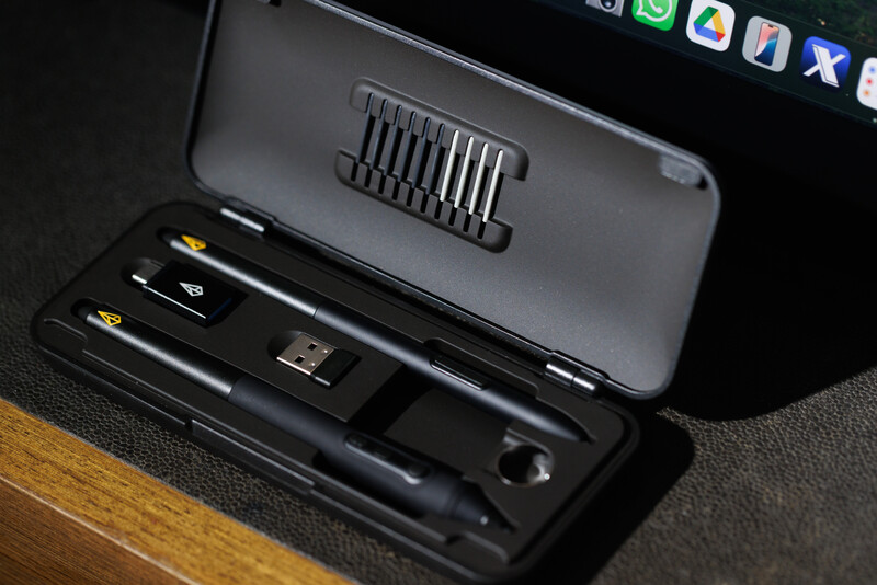 Mobile phone accessories laid out in an open black case, including charging cables, adapter, and cord organizers.