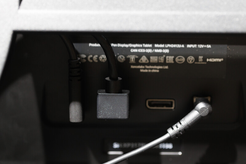 Rear panel of a flat-screen display showing ports, power input, and HDMI connection with cable attached.