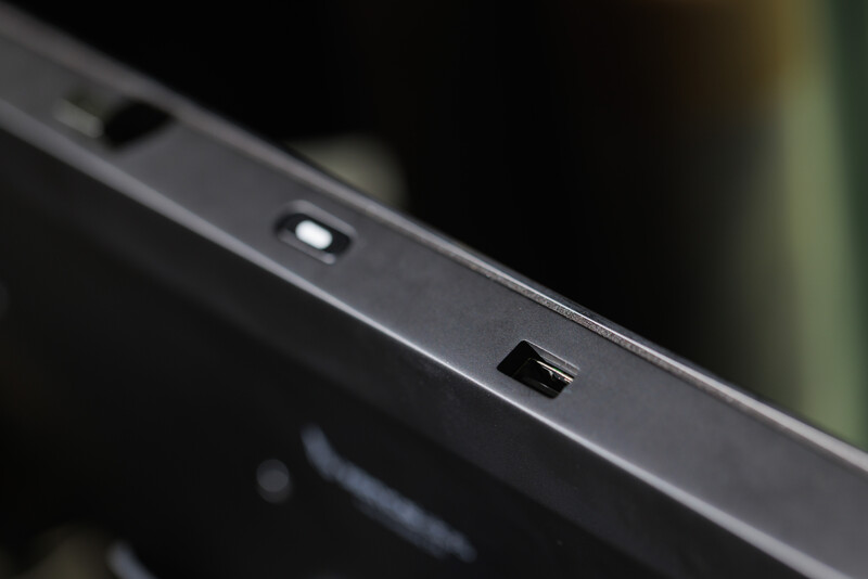 Close-up of a laptop's top edge showing a small LED indicator light and USB port against dark metal casing.