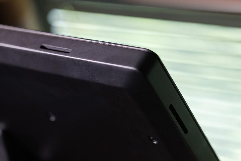 Close-up of a dark device edge showing a narrow slot opening against blurred background.